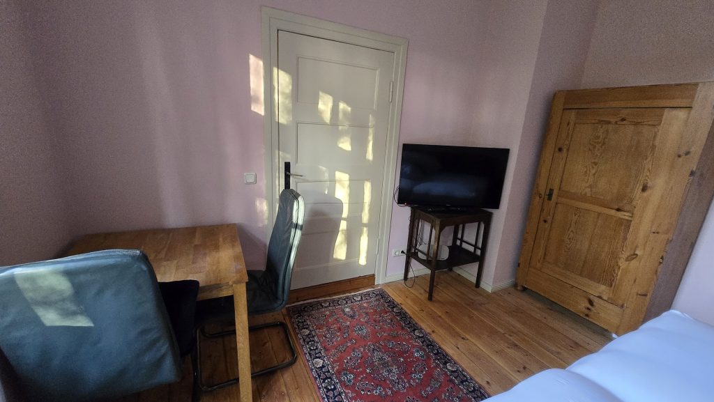 Blick aus dem Schlaf-/Wohnzimmer auf TV und Zimmertür